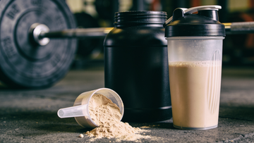 Misurino di proteine in polvere su cemento con shaker e dischi da palestra